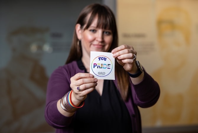 Person holding a pride sticker